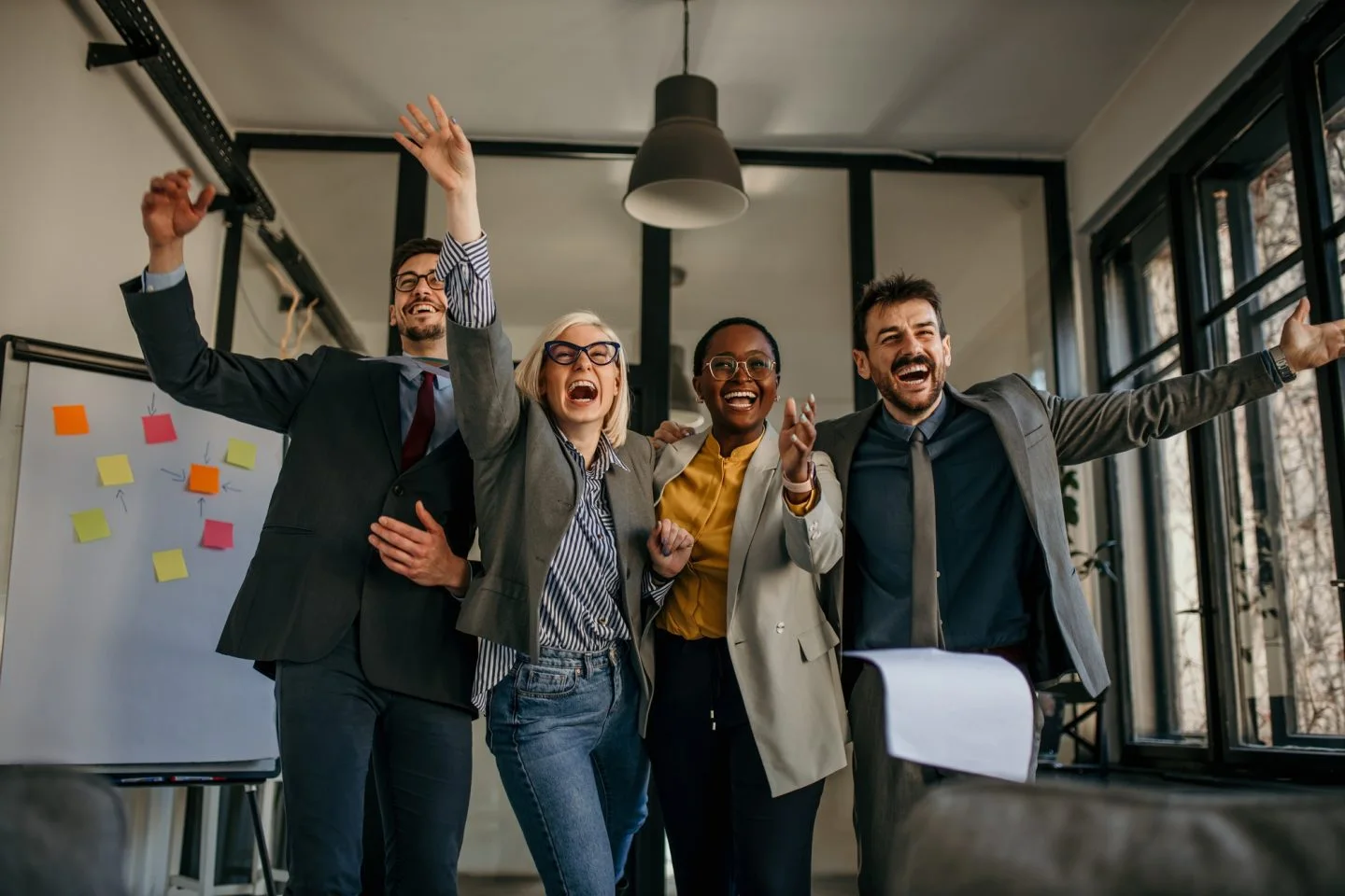 excited business team celebrating success in modern office